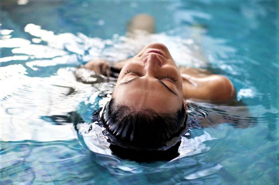 Persona che galleggia rilassata in piscina.